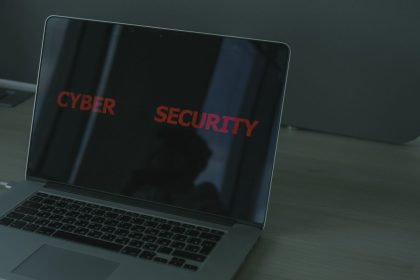 Laptop exibindo conteúdo relacionado à segurança cibernética em uma tela escura.