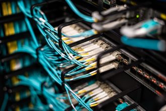 Cabos conectados a um painel de rede em um data center moderno.