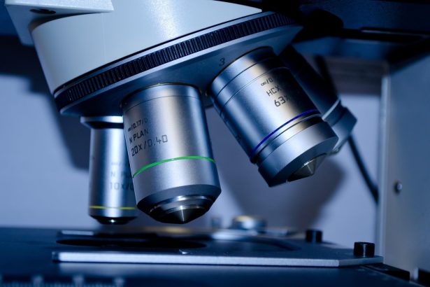 Microscópio examinando uma lâmina com amostra em um laboratório de pesquisa biomédica