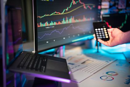 Telas exibem gráficos e dados de análise financeira em uma configuração digital de escritório.